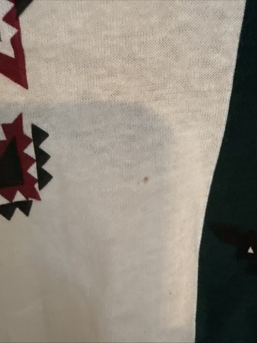White vintage T-shirt with faint black and red triangular geometric pattern on lower right side.