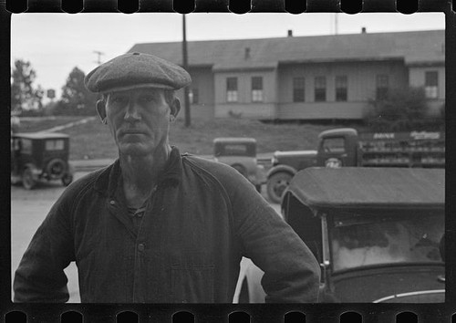 Photo:1930s Man in Flat Cap With Vintage Cars Storefront