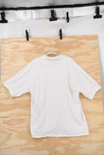 White vintage Harley-Davidson Sturgis 2002 men’s 2XL polo shirt with short sleeves, shown on a wooden background.