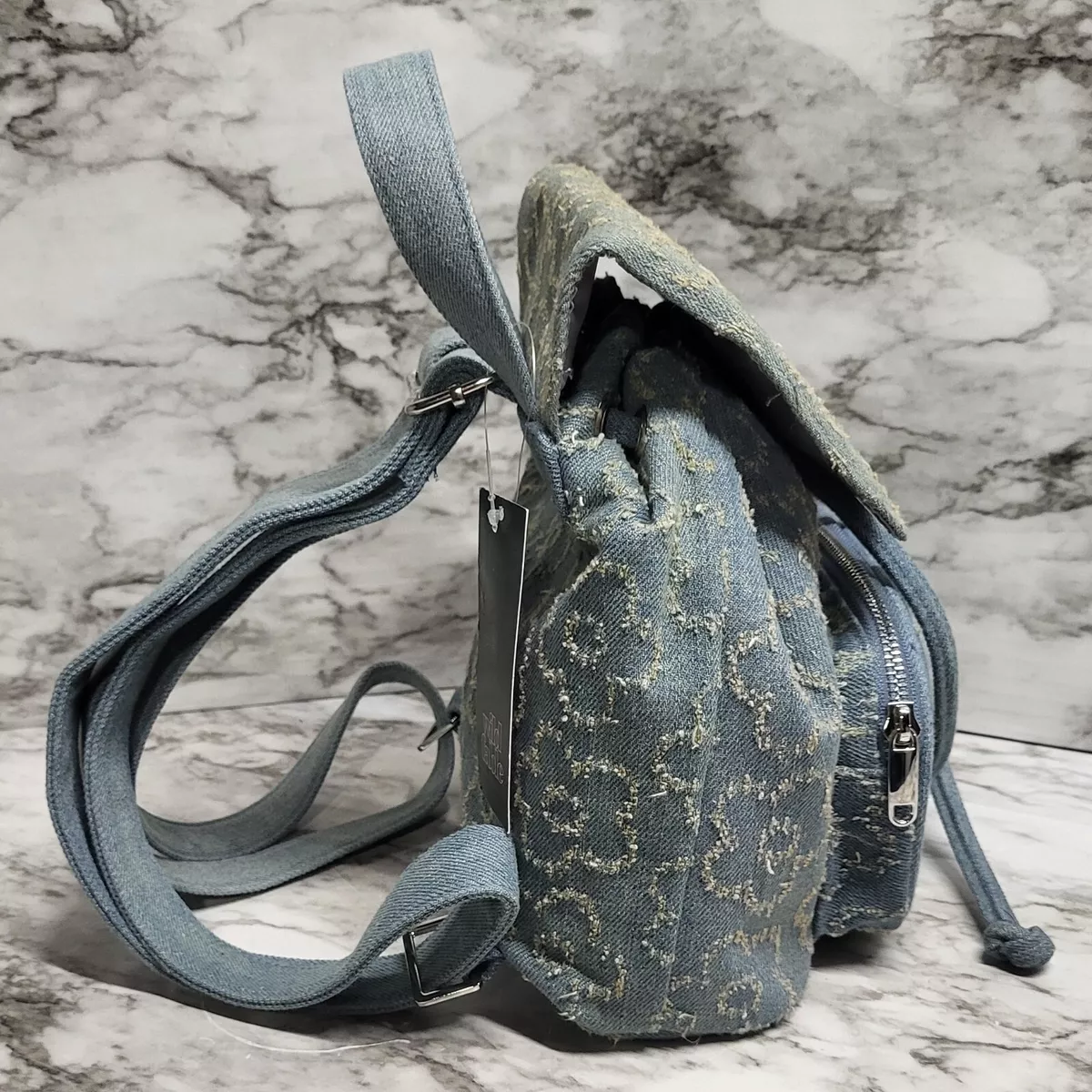 Mini Denim Backpack Purse. Frayed Flower Pattern. Cinch closure. Flap.  Zipper