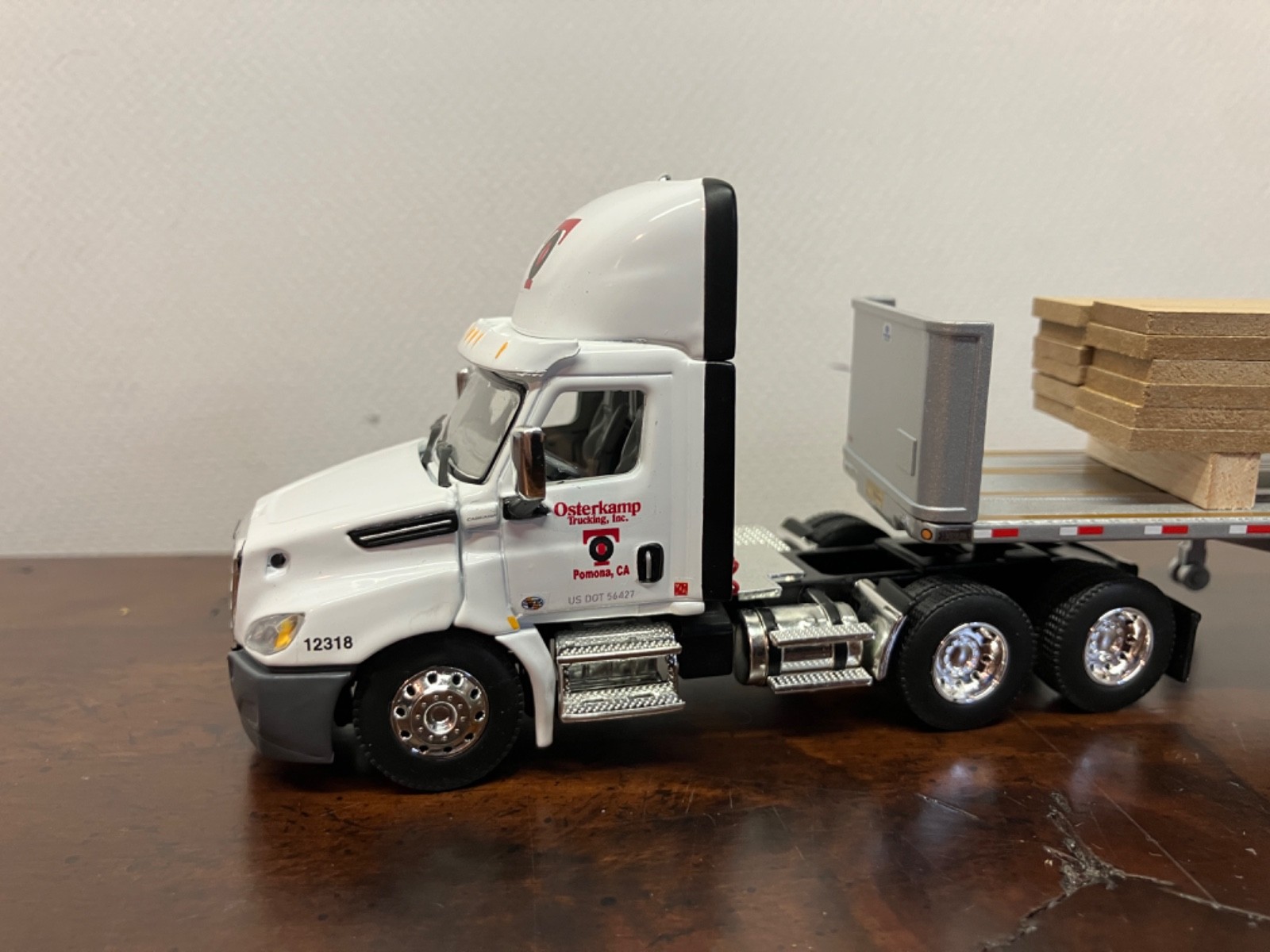 DCP First Gear 1/64th Osterkamp Trucking Cascadia Day Cab and 45' Flatbed w/load