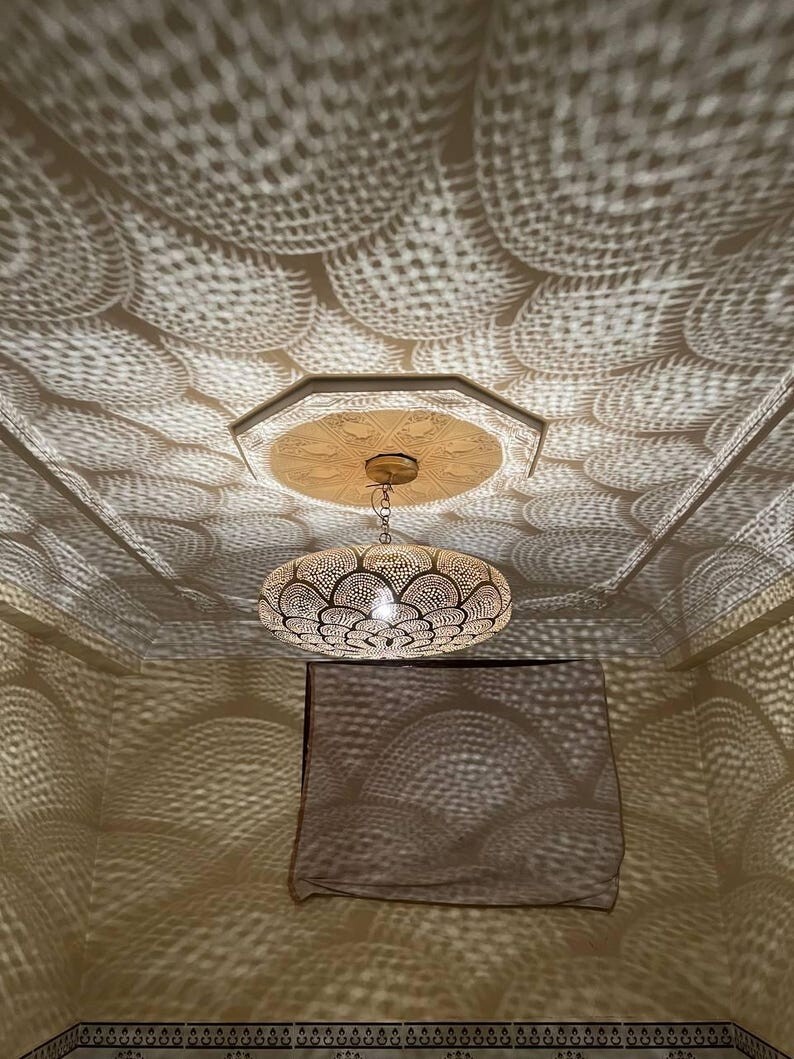 Brass Moroccan pendant light with intricate design and warm glow