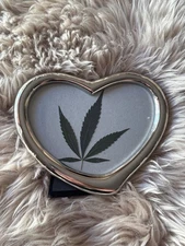 real dried pressed hemp leaf in a heart frame