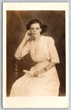 Postcard RPPC Young Lady Seated Holding Diploma Watch Necklace Studio Portrait