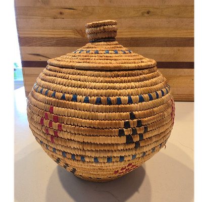 Coiled Yupik basket with lid featuring dyed geometric motifs. Artist signed tag