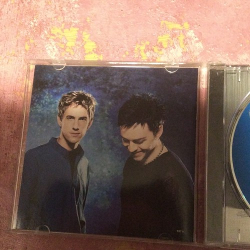 CD cover of Savage Garden’s “Affirmation” with blue-toned cityscape and two figures in black clothing.