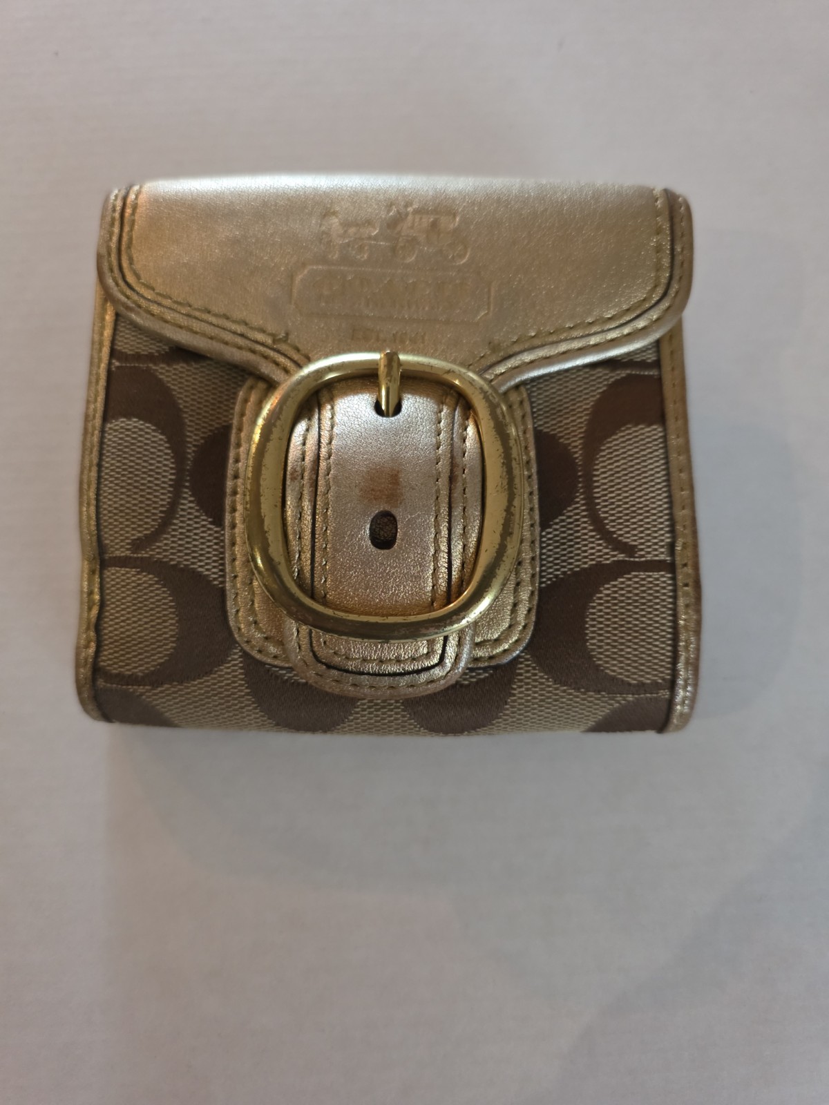 Coach signature buckle wallet in gold and brown.