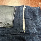 Black leather Gustin jeans patch on waistband, tan fabric strip, and white “GUSTIN” label on inner collar.
