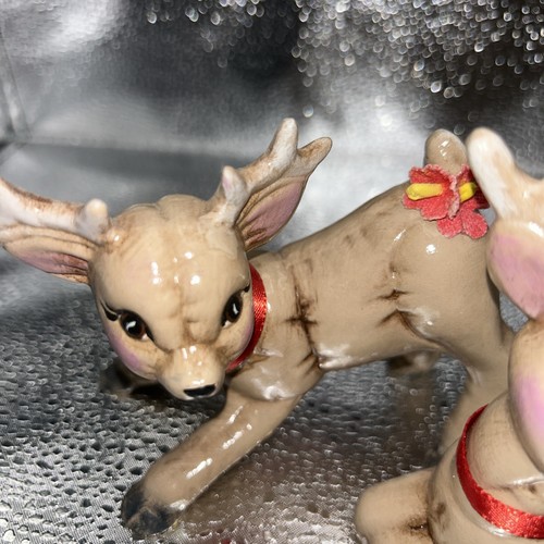 Pair of vintage Christmas REINDEER BABIES, one lying on silver with red bow, one standing with silver antlers.