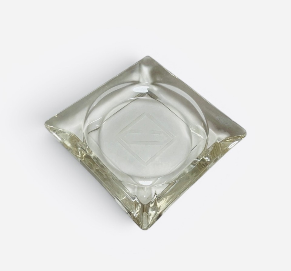 A set of square etched-glass ashtrays repurposed as sophisticated mid-century trinket dishes — the kind of barware-meets-desk-decor that looks curated, not cluttered.