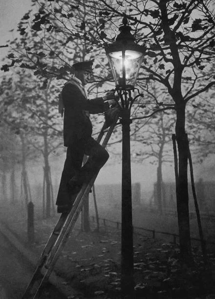 Lamp lighter relighting a gas lamp in the fog on November 17 1930 Old Photo