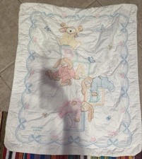 Handmade cross-stitch baby quilt with personalized names and dates.