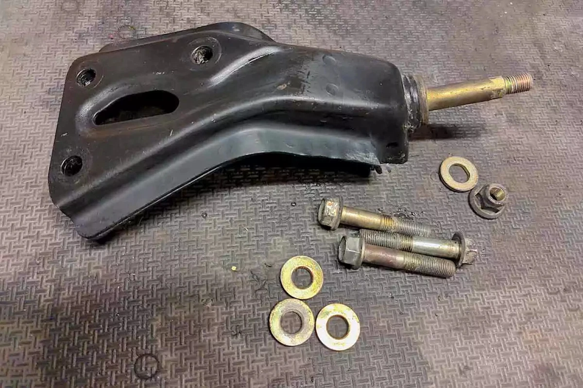A previously owned OEM 1996-2000 Honda Civic manual transmission mount displayed on a gray textured surface.