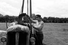 British sculptor Phillip King works on the engine of a tractor in - Old Photo