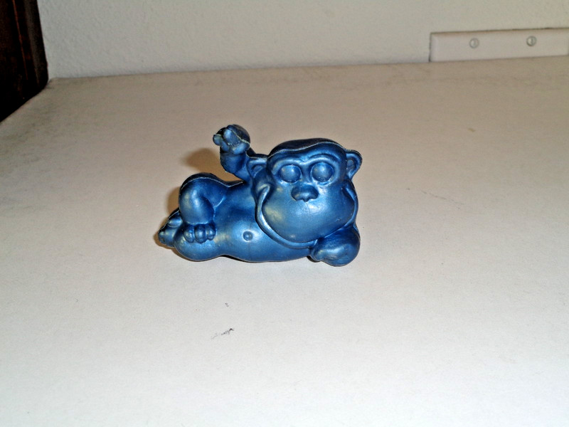 Vintage Hollow Plastic Monkey Laying on their Side with Finger Pointing Up