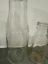 3 different size vintage milk bottles.