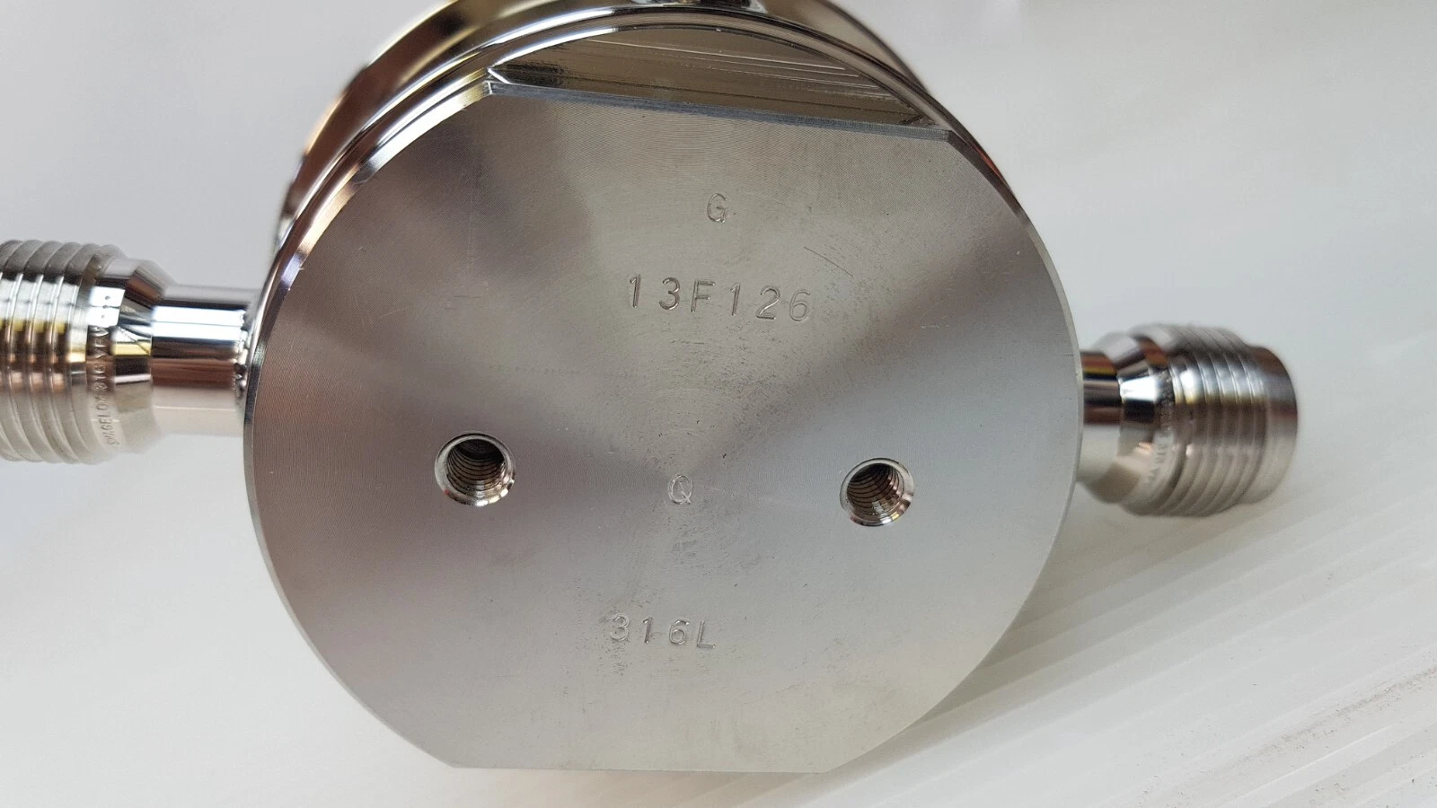 Bottom of the regulator body stamped 13F126 and 316L, with two threaded mounting holes