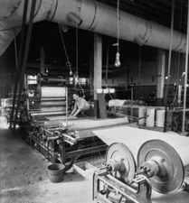 Man operates machinery an unspecified paper mill, finished paper b Old Photo