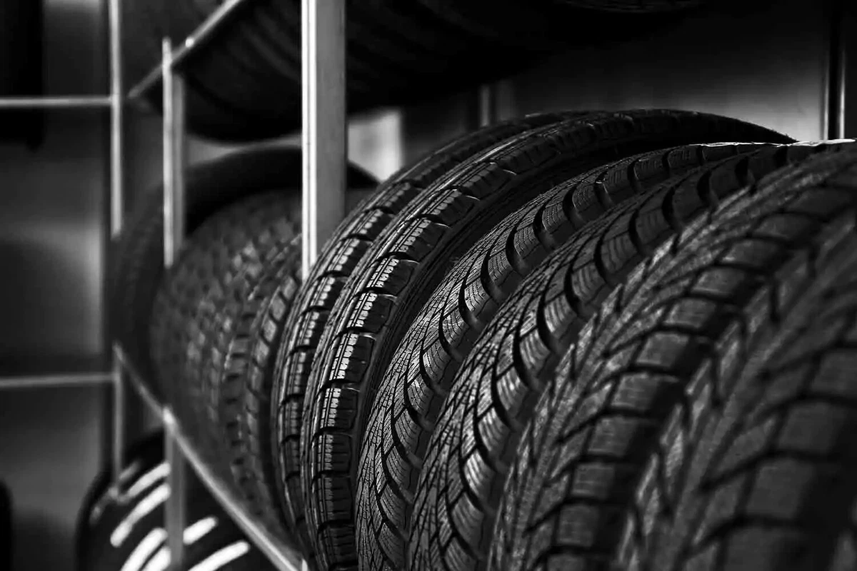 A group of brand-new tires sitting on a tire rack.