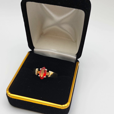 gold-toned fashion statement ring with vibrant,  red marquise-cut center stone