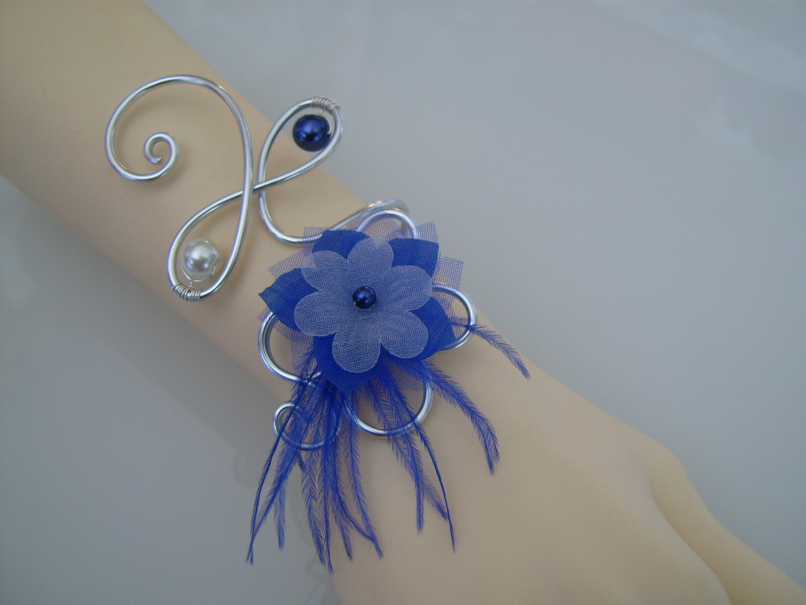 Bracelet fleur bleu électrique et plume ivoire pour sublimer une robe de soirée