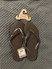 Havaianas brown flip flops with metallic straps.