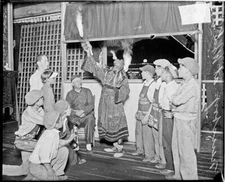 Person Wearing A Costume Eating Fire In Front Of A Booth At White - Old Photo