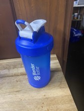 A blue Blender Bottle with a lid, featuring a spout for easy pouring.