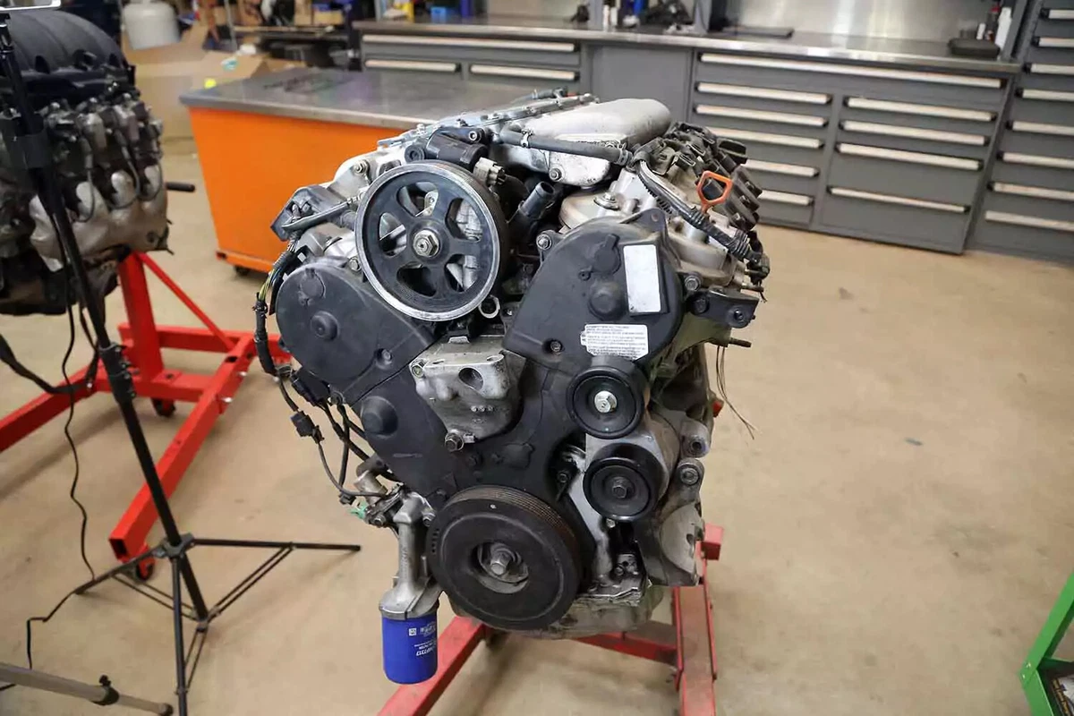 A V-6 engine on an engine stand in a workshop.