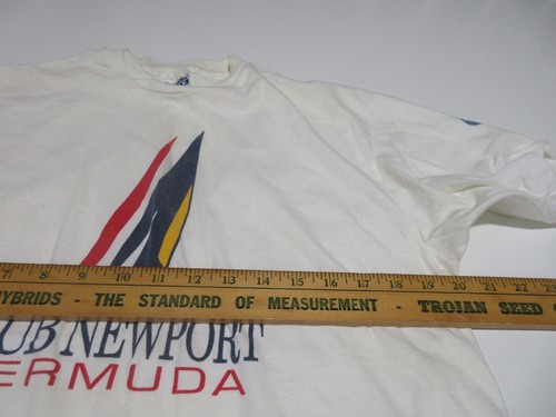 White Sz L men’s T-shirt with blue, red, and yellow club Newport Bermuda logo, next to a wooden ruler and text.