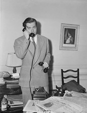Orson Welles is busy taking telephone calls reading newspapers on - Old Photo