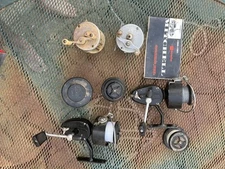 Lot of 4 vintage fishing reels, one instruction manual.