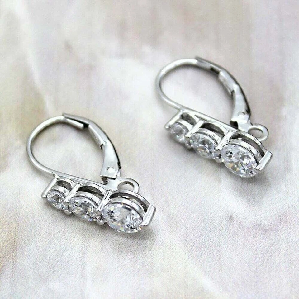 Pendientes colgantes de tres piedras de corte redondo de 3 quilates para mujer enchapados en oro blanco de 14 quilates Foto 3 de 4