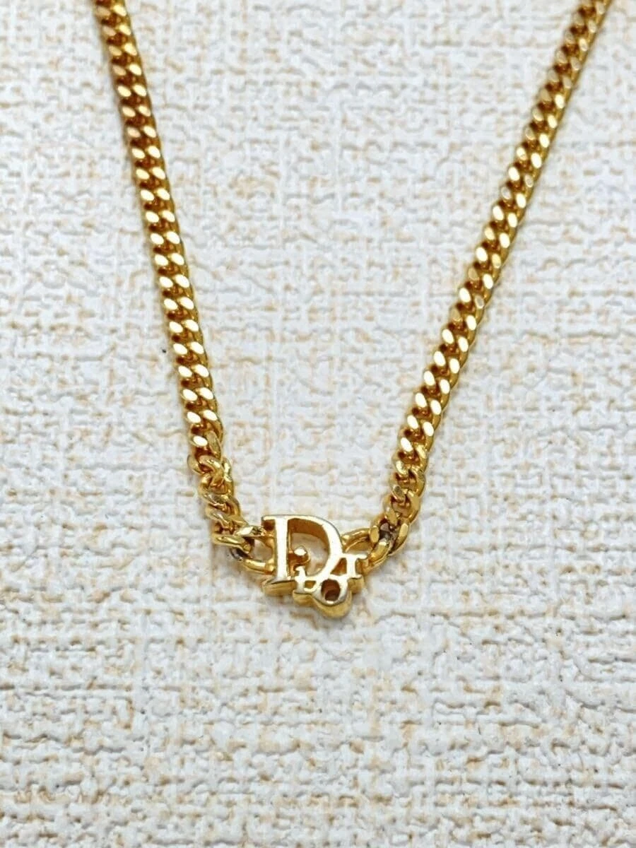 Mini logo Christian Dior    Haut doré avec femme