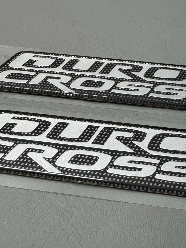 Mitsubishi Raider Duro 2006-2009 emblema de puerta lateral cruzada logotipo insignia usado conjunto OEM Foto 3 de 4