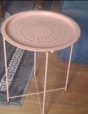 This pink, circular piece is a folding metal tray-top side Table