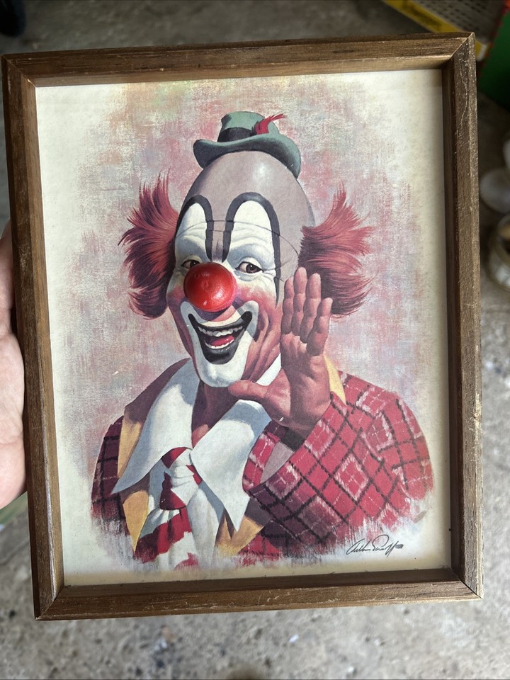 A wind-up clown music box framed as wall art by Arthur Sarnoff — bizarre, kitschy, and weirdly wonderful mid-century americana.