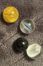 3 Cat's eye marbles, 1 Black Marble