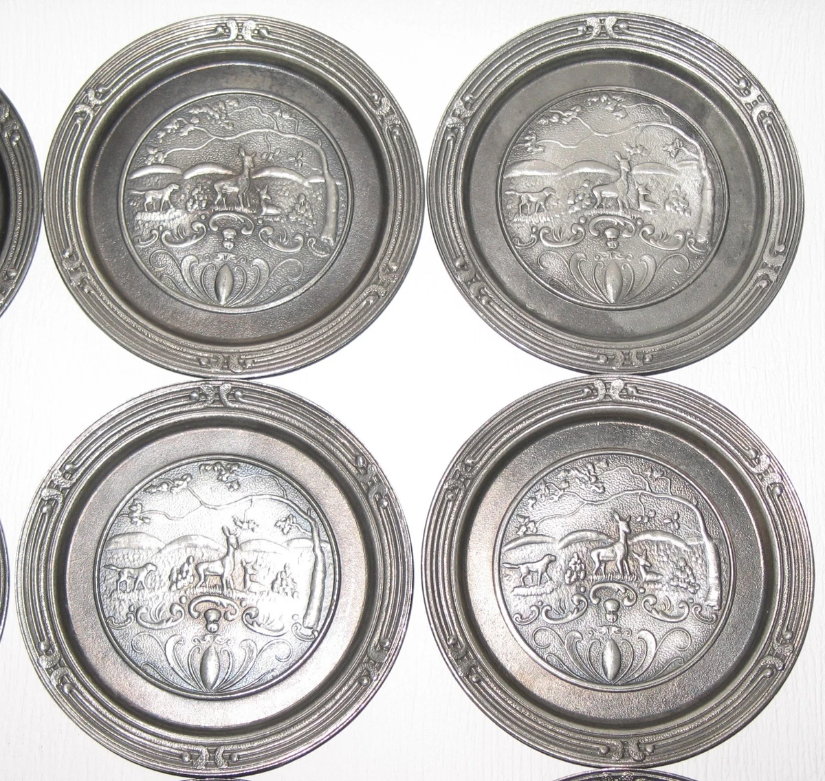 Neunteiliges Zinn-Untersetzer-Set mit detaillierten Relief-Jagdmotiven (Rehe, Ja