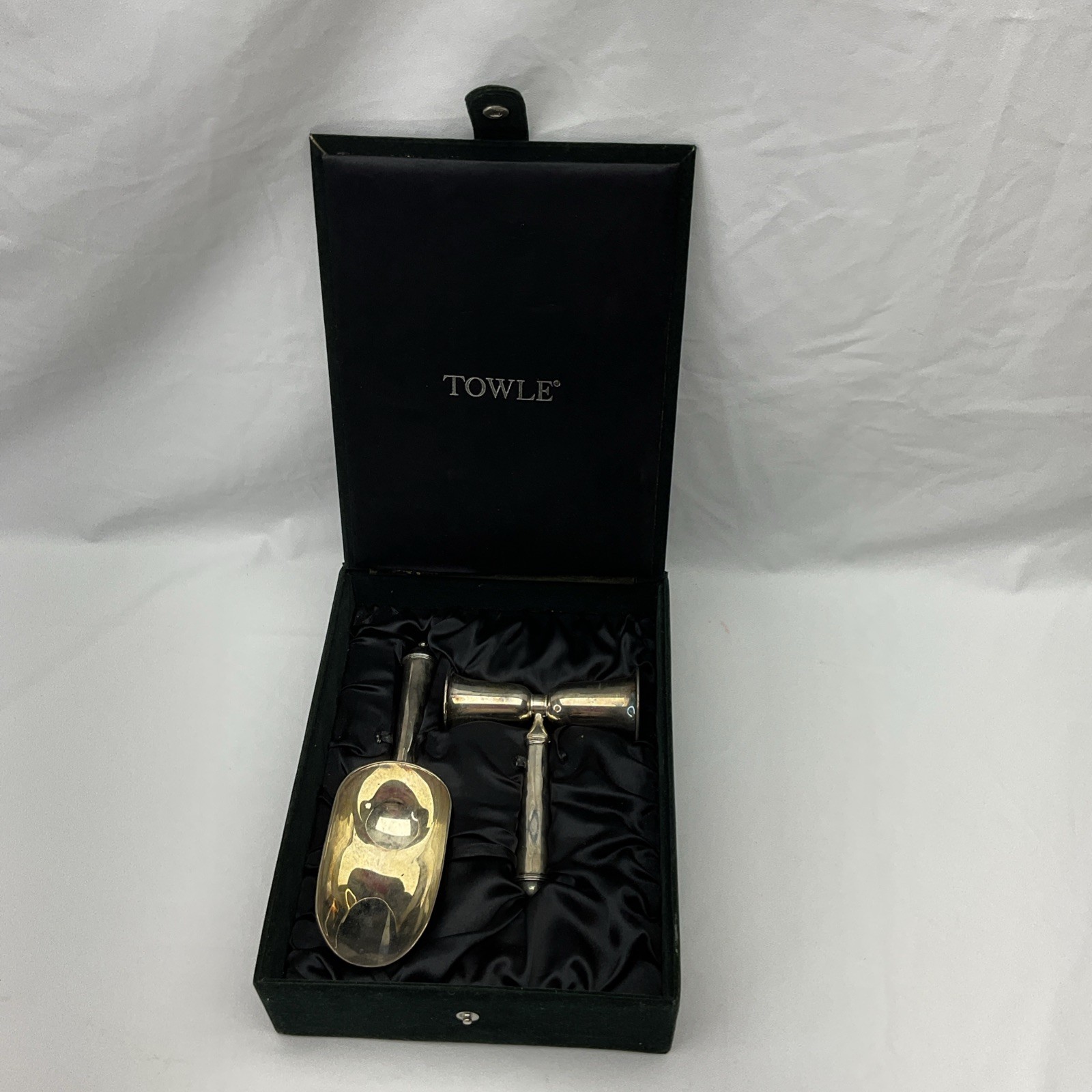 Silver-plated jigger and ice scoop resting in a black Towle presentation case.