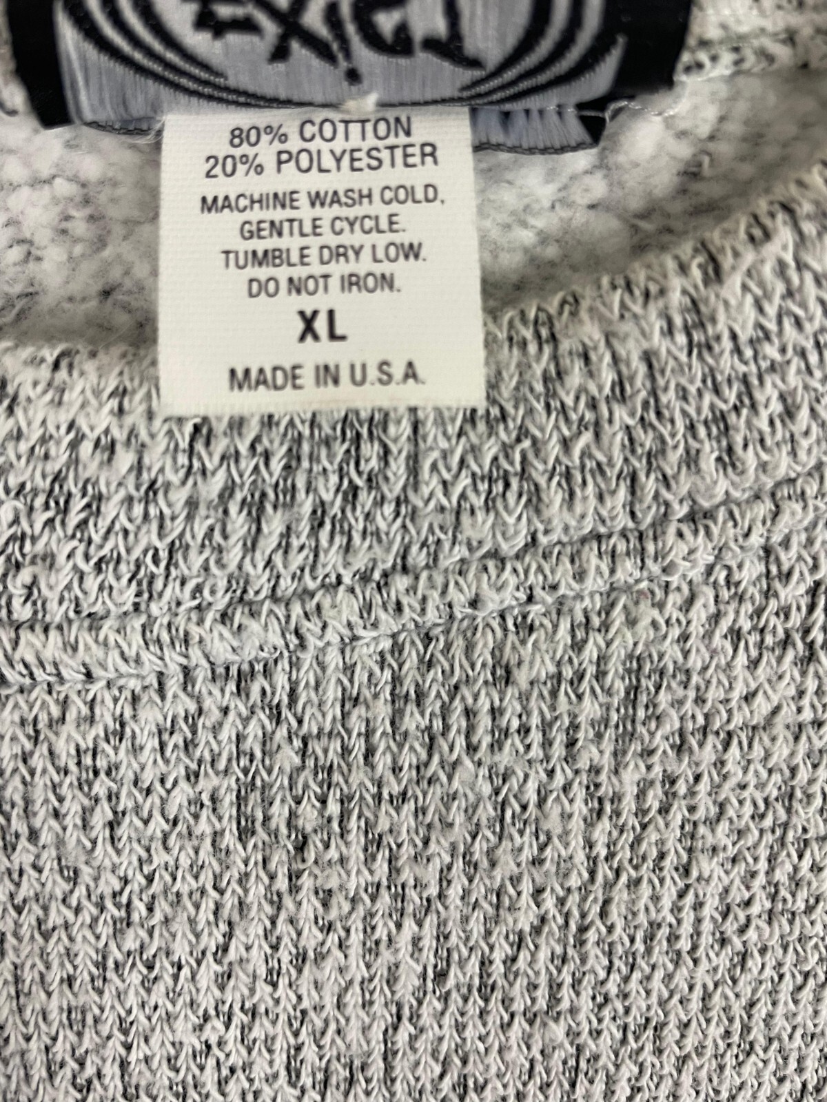 Gray vintage pullover sweater with black trim, white label showing fiber content, machine wash, and “Made in U.S.A.”