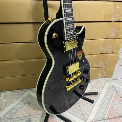 Black 6-string LP electric guitar with gold hardware and white binding in stock