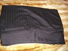 Black vintage pin stripe mini skirt with front welt pocket, belt loops, and double button closure, laid flat on fabric surface.