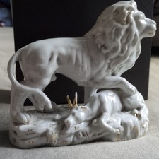 Porzellanfigur Löwe mit Beutetier, weiß/gol...