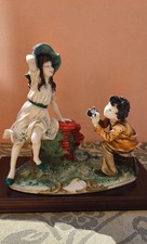 Statua Capodimonte con base in legno bambini su un'altalena di Giuseppe Armani