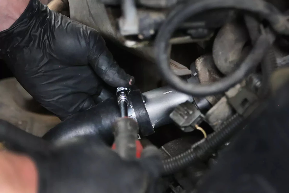 Tightening the worm-gear clamp with a screwdriver.