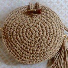 Borsa beige lavorata a mano a uncinetto.