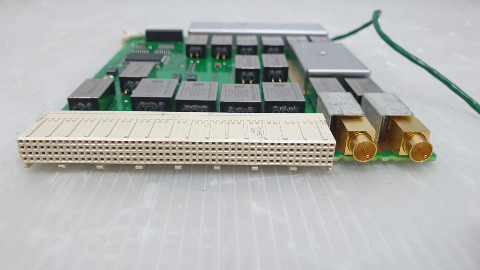 Edge view of the E3121-66611 multi-row backplane connector and two gold coax jacks
