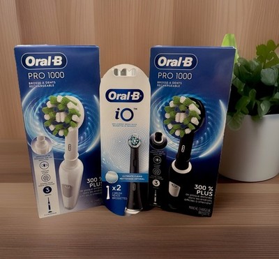 Oral-B Lot: (2) Pro 1000 Electric Toothbrushes+ (1) Pack Of Replacement Heads