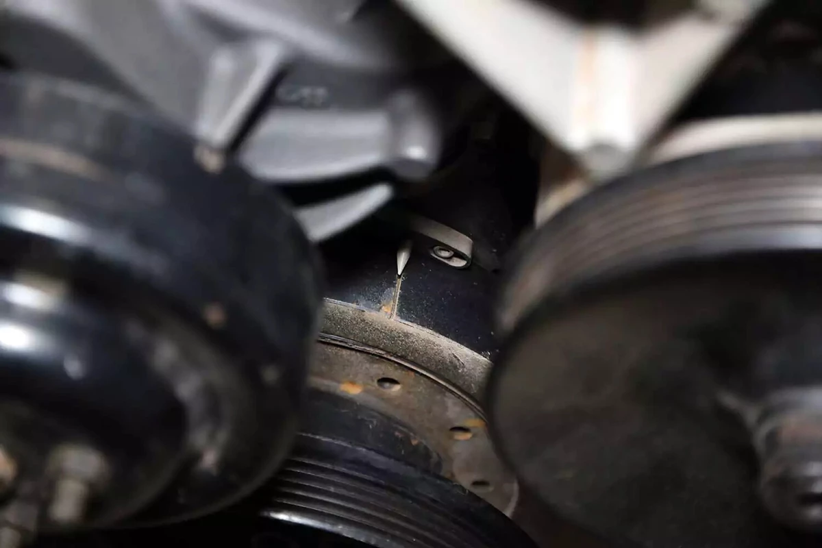 With the engine running, a timing light shows that the timing mark and tab are aligned.